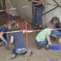 Foto: Fünf Kinder graben mit Kellen Funde aus der Erde aus.
