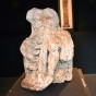 Gezeigt wird eine Steinmetzarbeit die einen thronenden Jupiter als Figur darstellt, der auf einer schwarzen Säule aufgestellt ist.