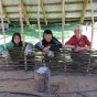 Aufbau einer Flechtwerkwand, davor drei Teilnehmerinnen des Workcamps