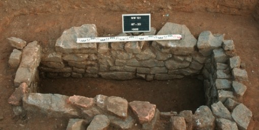 Das Foto zeigt ein aus Grauwackebruchstücken sowie Ziegelbruchsteinen gemauertes Steinkammergrab.